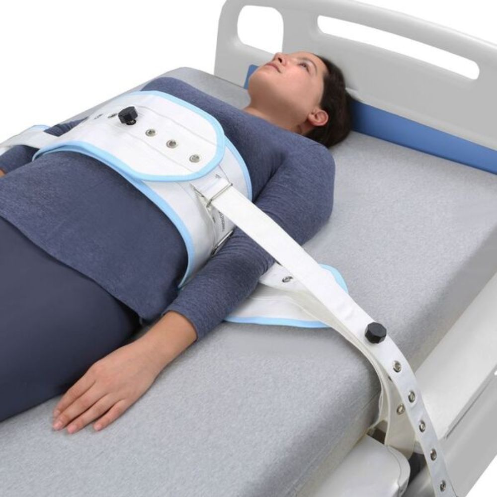 Contención de paciente con sujeción blanca y azul, cierres magnéticos en el torso.